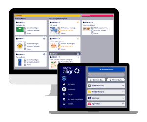 Two computer screens display different software dashboards with various icons, menus, and navigation options, helping streamline workflow in a busy Print Shop.